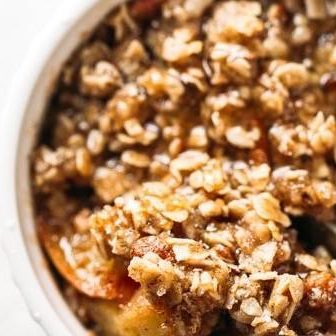 Coconut Oil Apple Crisp in a pan with a wooden spoon.