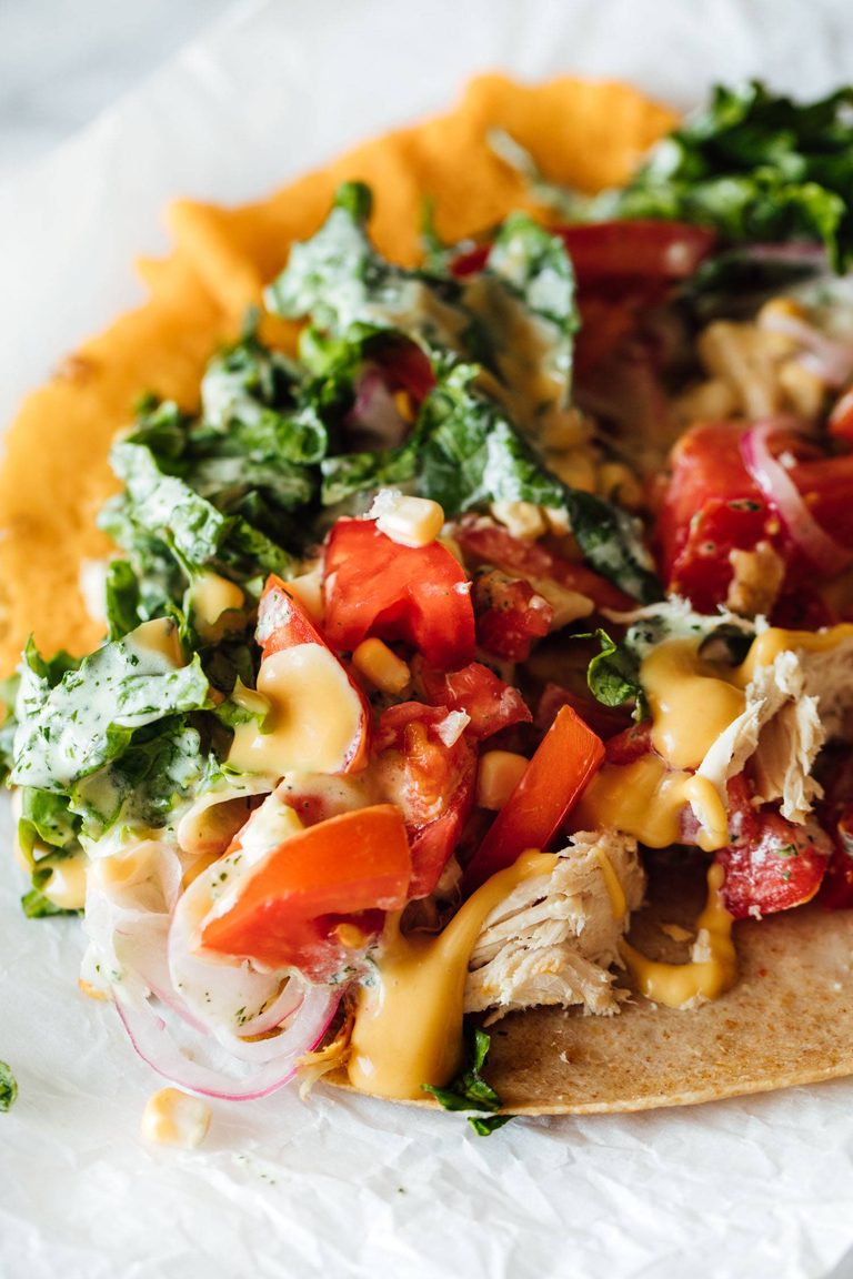 Chicken wrap with kale, tomatoes, and sauce.