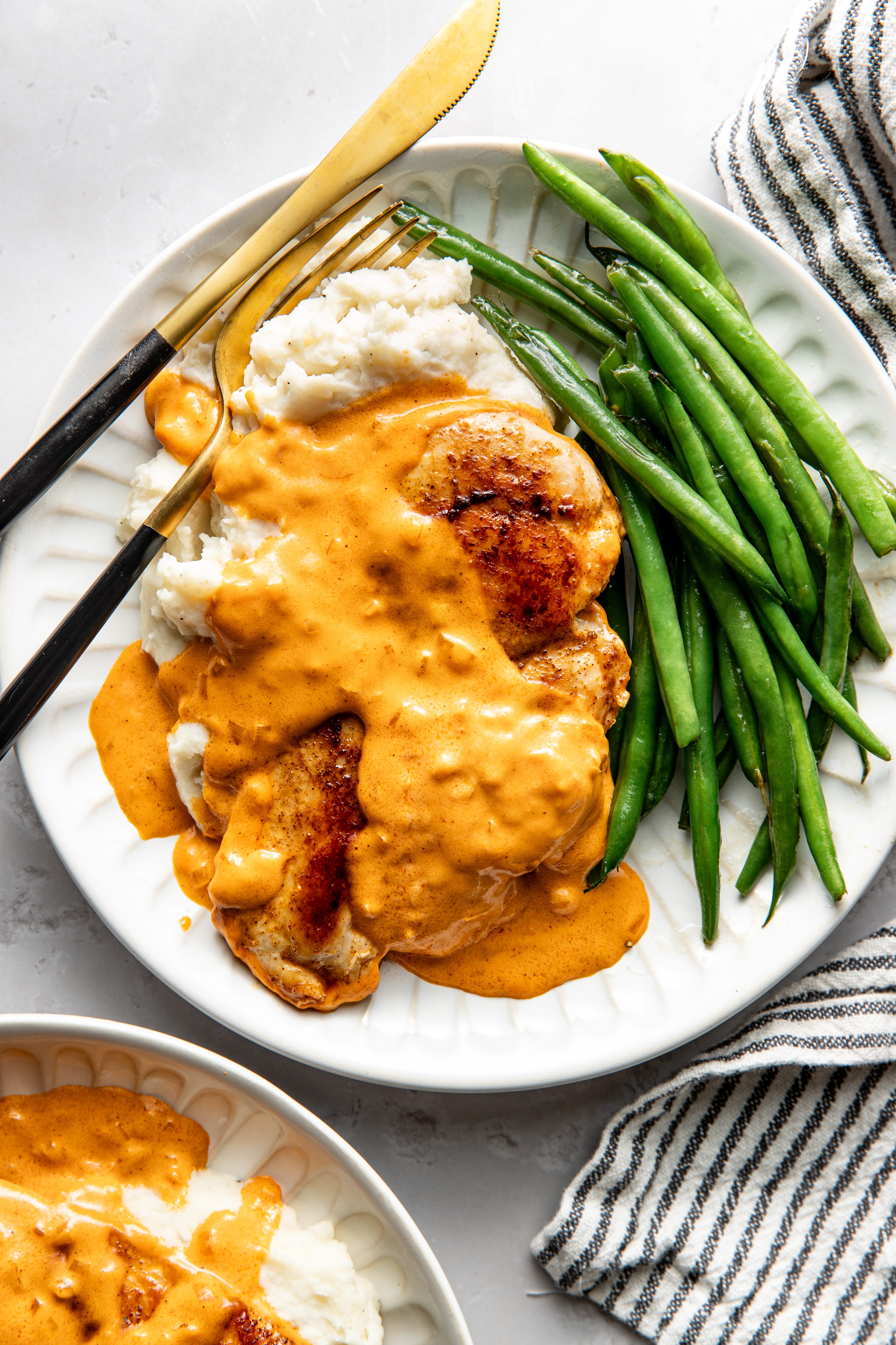 Chicken in cajun sauce with mashed potatoes and green beans.